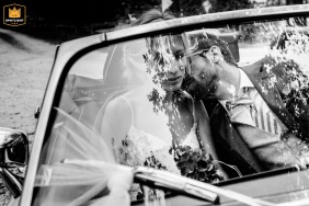   Inside a car in Bern, Switzerland, the groom leans in for a quiet kiss with his bride, offering them a private, intimate escape from the day’s celebrations.